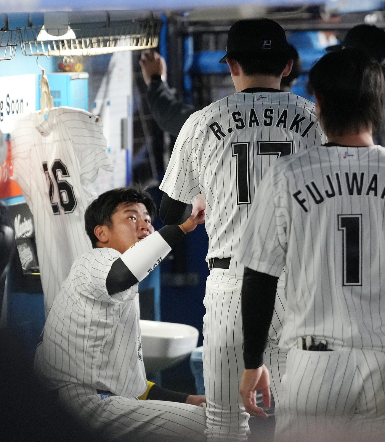 ロッテ対ソフトバンク　3回表を終え、松川（左）とタッチを交わし、ベンチから引き揚げるロッテ佐々木朗（撮影・鈴木みどり）