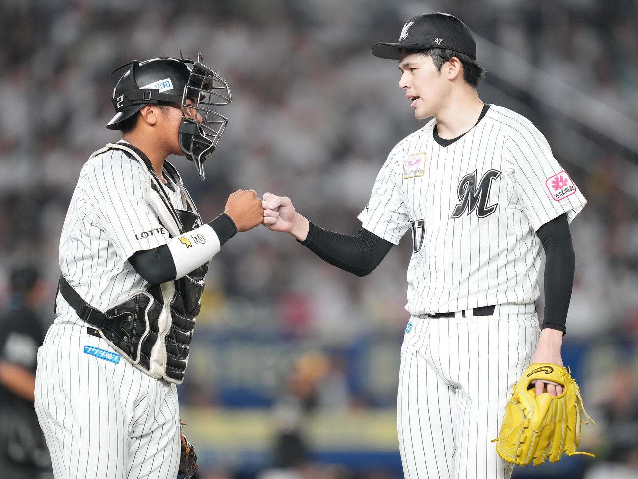 ロッテ対ソフトバンク　3回表を3者凡退に抑え、松川（左）とタッチを交わすロッテ佐々木朗（撮影・鈴木みどり）