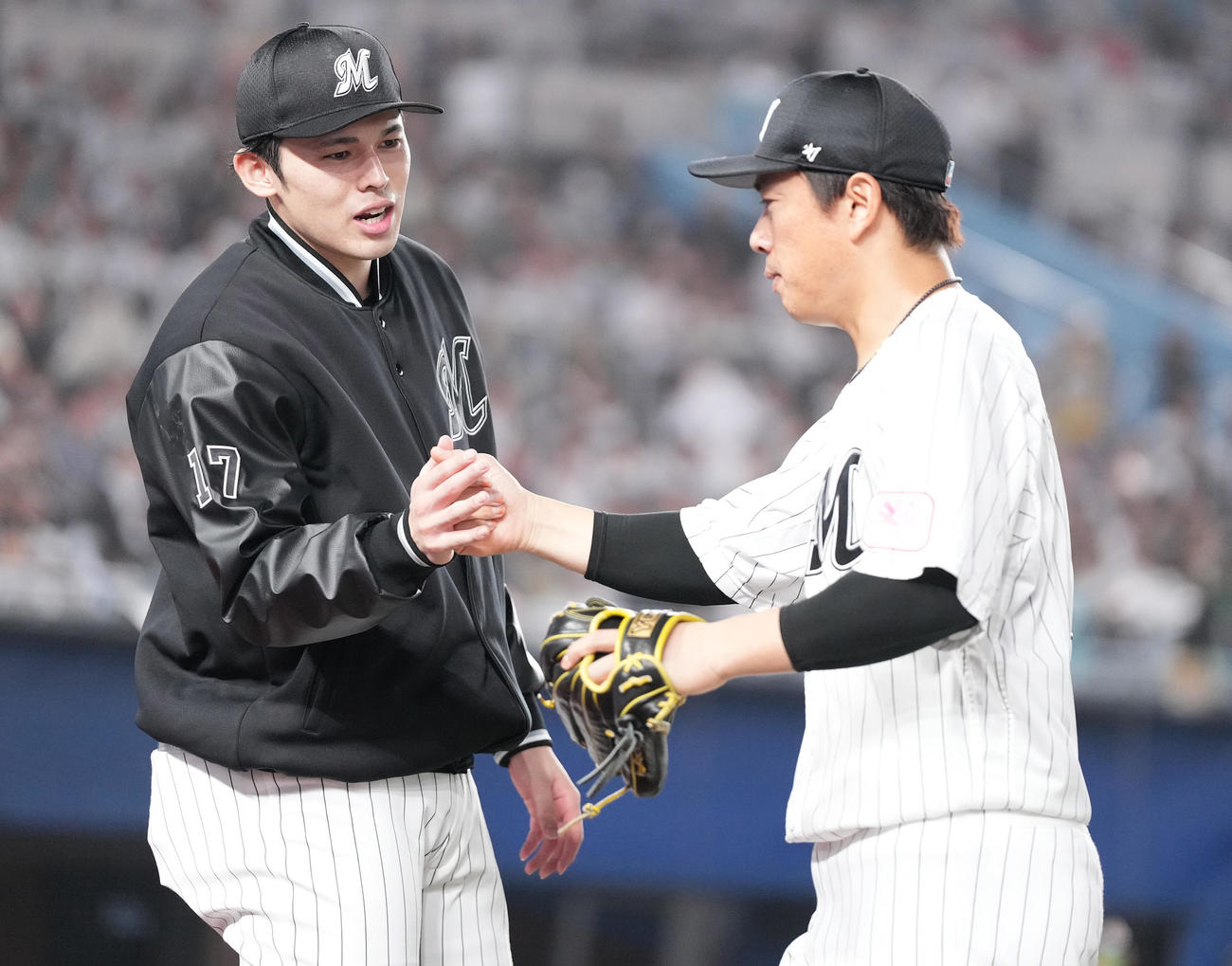 ロッテ対ソフトバンク　4回表を抑えた角中（右）らナインを迎えるロッテ佐々木朗（撮影・鈴木みどり）
