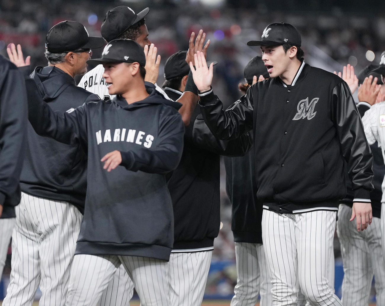 ロッテ対ソフトバンク　ソフトバンクに勝利し、吉井監督（左）とタッチを交わすロッテ佐々木朗（撮影・鈴木みどり）