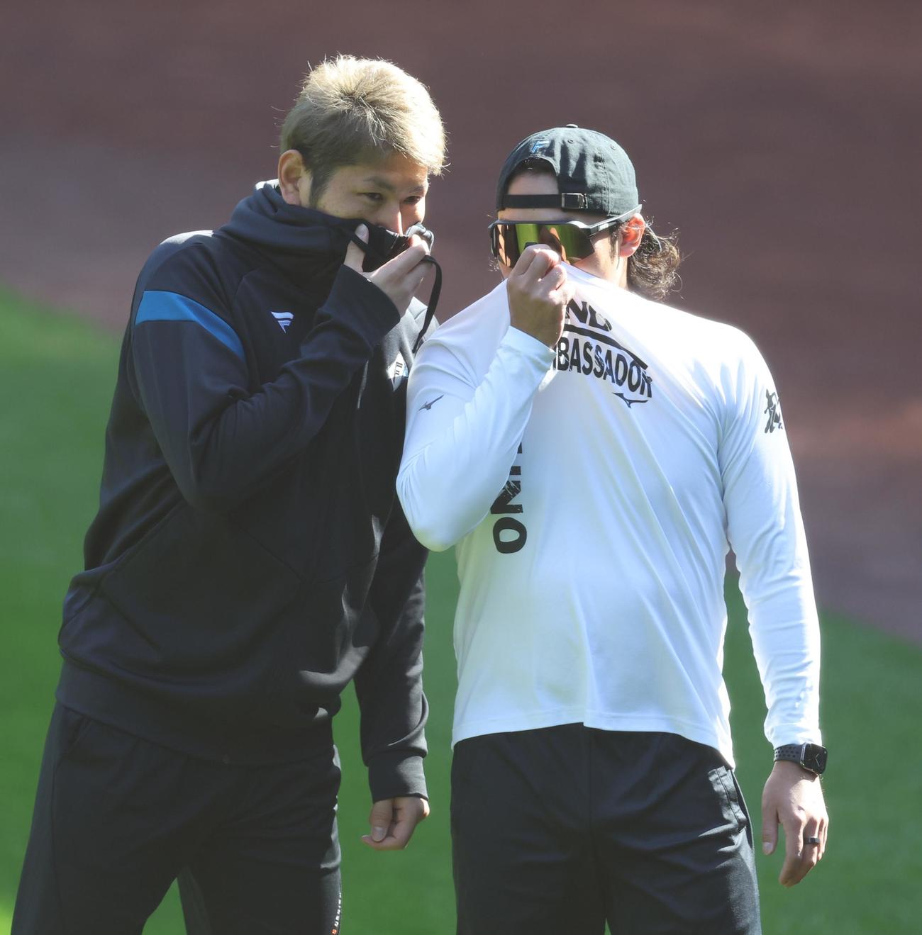 口元を隠しヒソヒソ話しする日本ハム加藤貴（左）と伊藤（撮影・黒川智章）