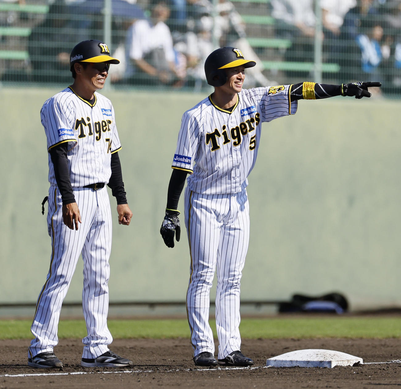 フェニックスリーグ阪神対日本ハム　6回裏阪神無死一塁、中野の右前打で三塁へ進み、コーチと笑顔で話しをする近本（右）（撮影・藤尾明華）