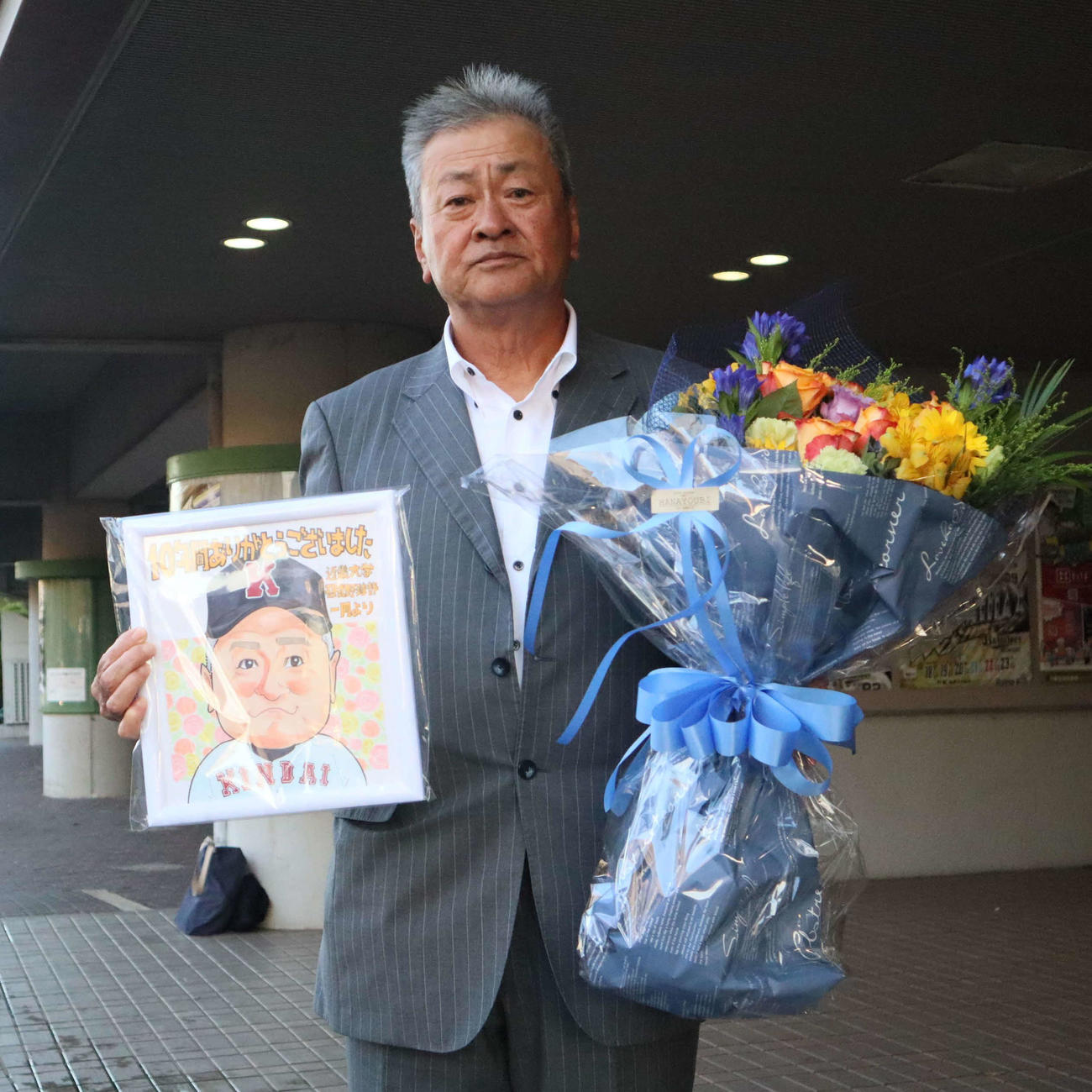 選手から花束と似顔絵をプレゼントされた近大の田中監督（撮影・村松万里子）