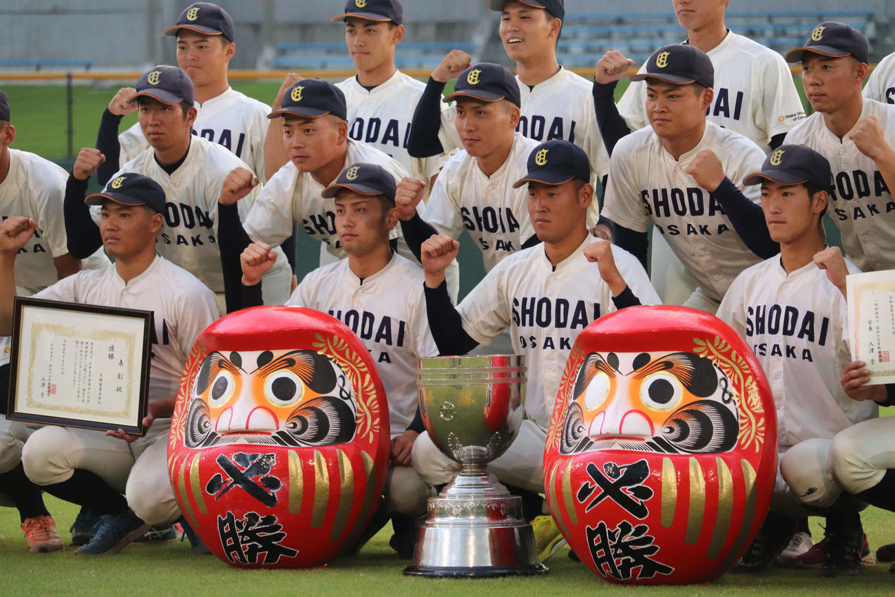 関西6大学野球　ドラフト候補投手コンビで大商大の上田大河主将はトロフィーの後ろで両手で拳をつくり、高太一（左端）は表彰状を手にガッツポーズ（撮影・中島麗）