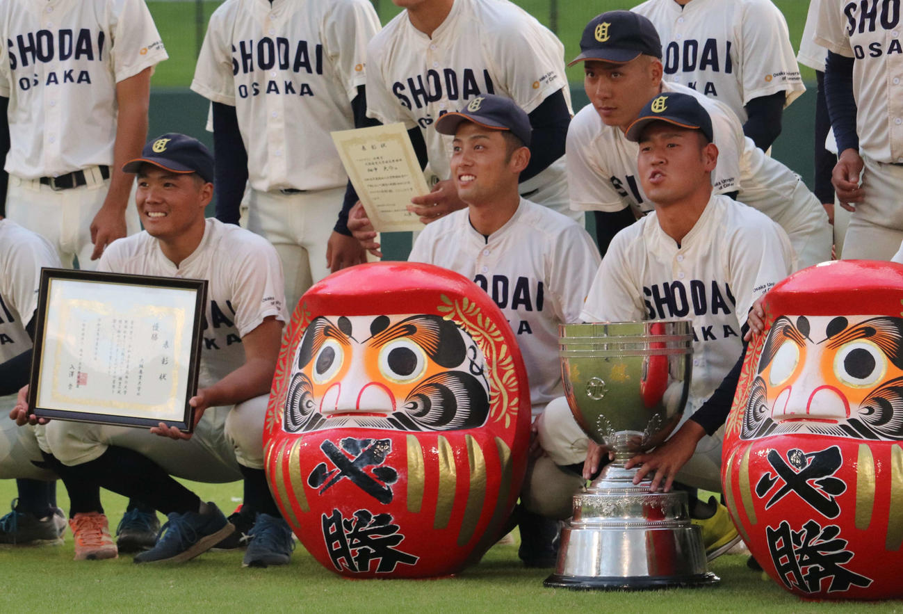 関西6大学野球　ドドラフト候補投手コンビで大商大の上田大河主将の両手はトロフィーに、高太一（左端）は表彰状を手に笑顔（撮影・中島麗）