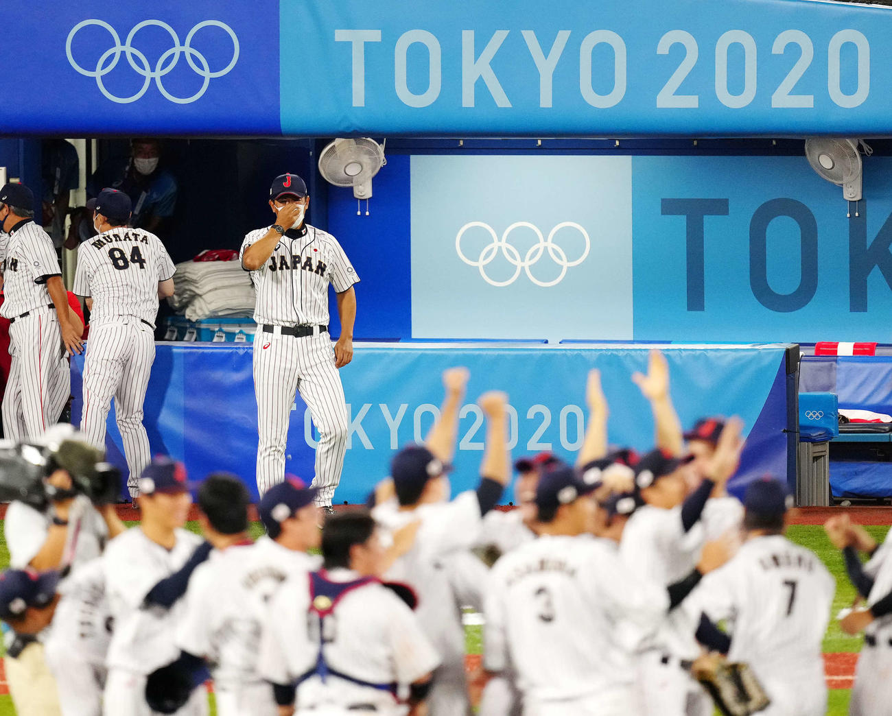 2021年8月7日、優勝を決め歓喜する日本の選手たちを涙を流しながら見つめる稲葉監督（後方右）