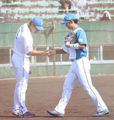 フェニックスリーグの試合中、引き揚げてくる日本ハム郡司（右）と握手する野村（撮影・永野高輔）