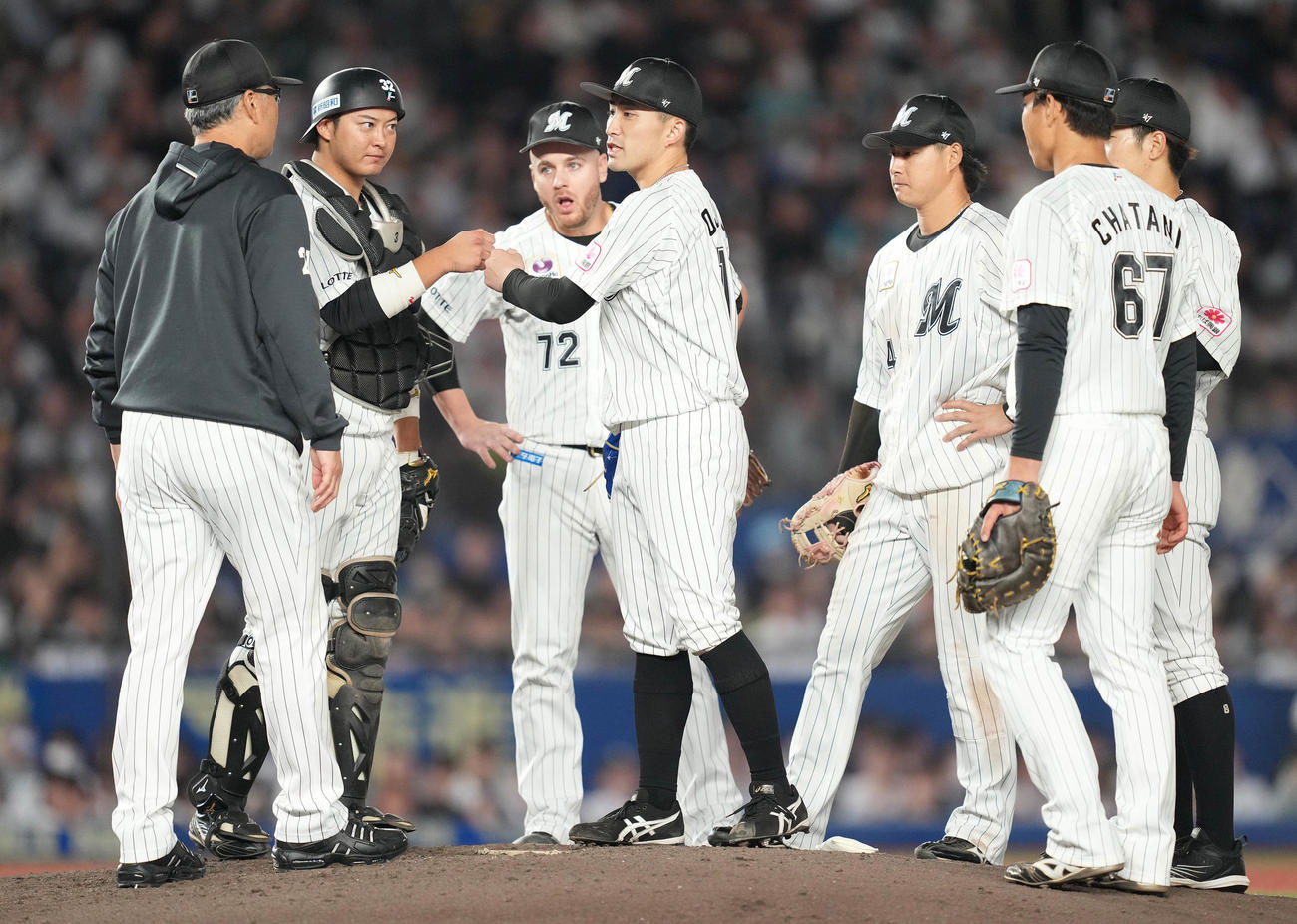 ロッテ対ソフトバンク　7回表途中で降板となったロッテ小島（中央）は捕手佐藤都（左から2人目）とタッチを交わす。左は吉井監督（撮影・鈴木みどり）