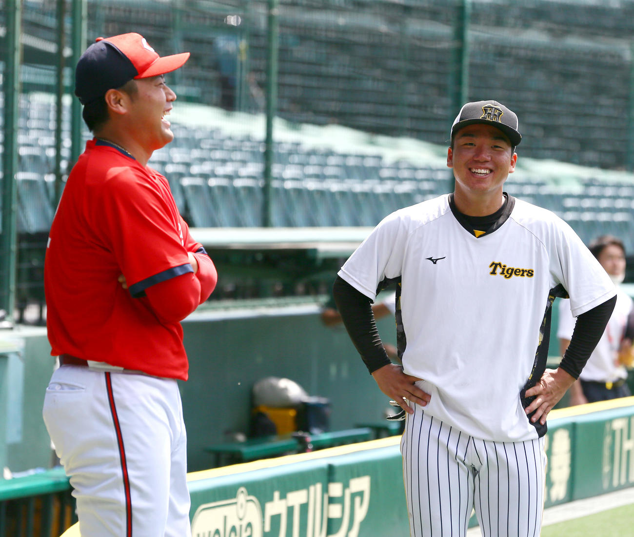 9月9日、試合前に東洋大先輩の広島末包（左）と話す阪神村上