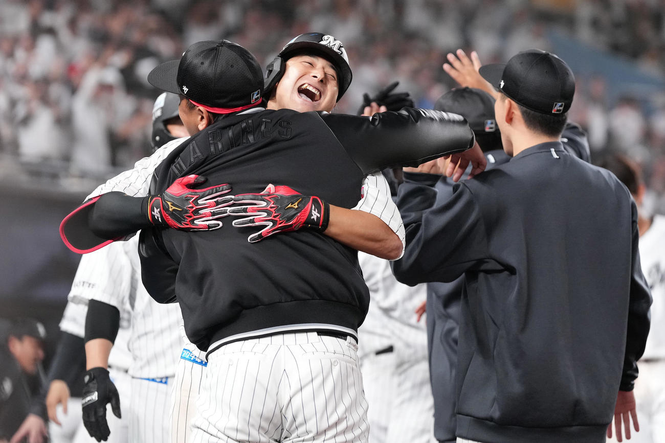 ロッテ対ソフトバンク　10回裏ロッテ無死一、二塁、右中間に3点本塁打を放ちナインとハグする藤岡（撮影・鈴木みどり）
