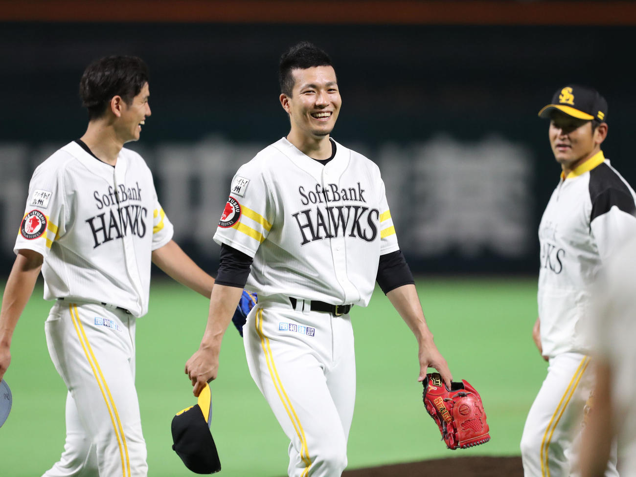 練習を終え、笑顔で引き揚げる千賀（中央）。右は投手コーチ時代の倉野信次氏（019年6月25日撮影）