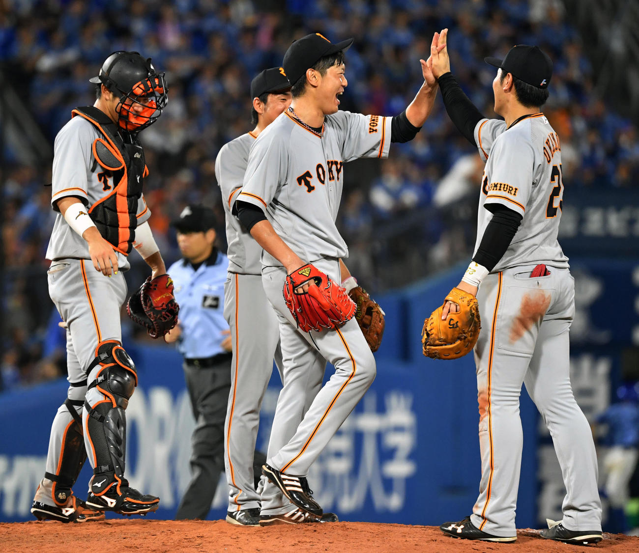 DeNA対巨人　完封勝利した巨人内海（右から2人目）は岡本（右）とハイタッチする（2018年7月31日撮影）
