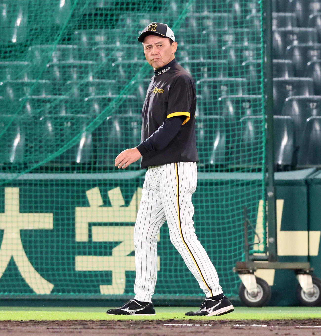 練習を終え厳しい表情でグラウンドを見つめて引き揚げる岡田監督（撮影・加藤哉）