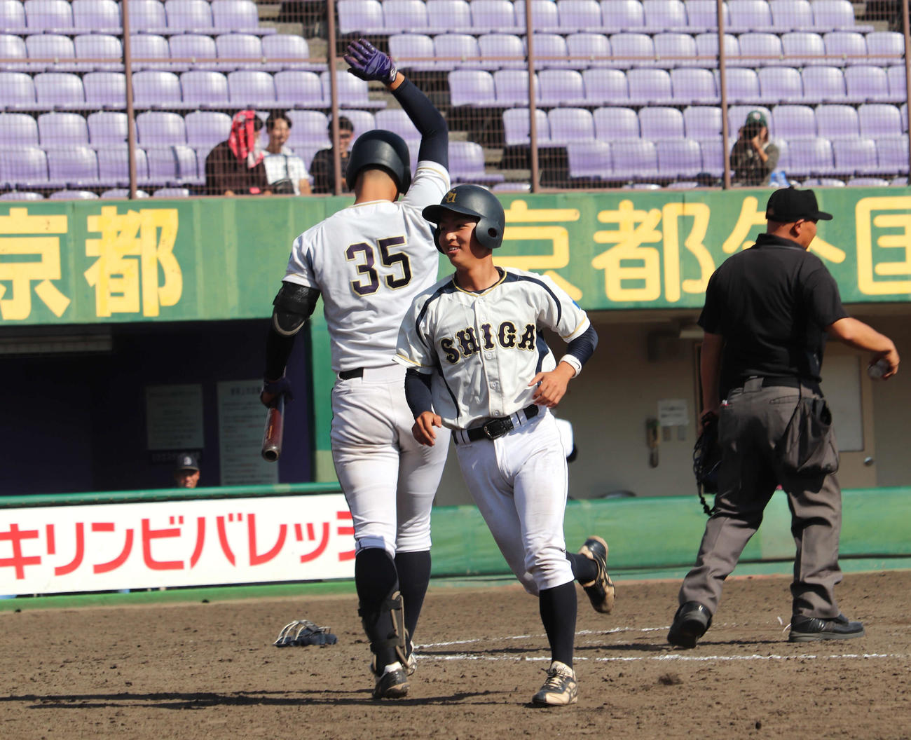 京滋大学野球　びわこ成蹊スポーツ大対滋賀大　5回2死三塁で暴投の間生還した、滋賀大佐野を迎えた若林
