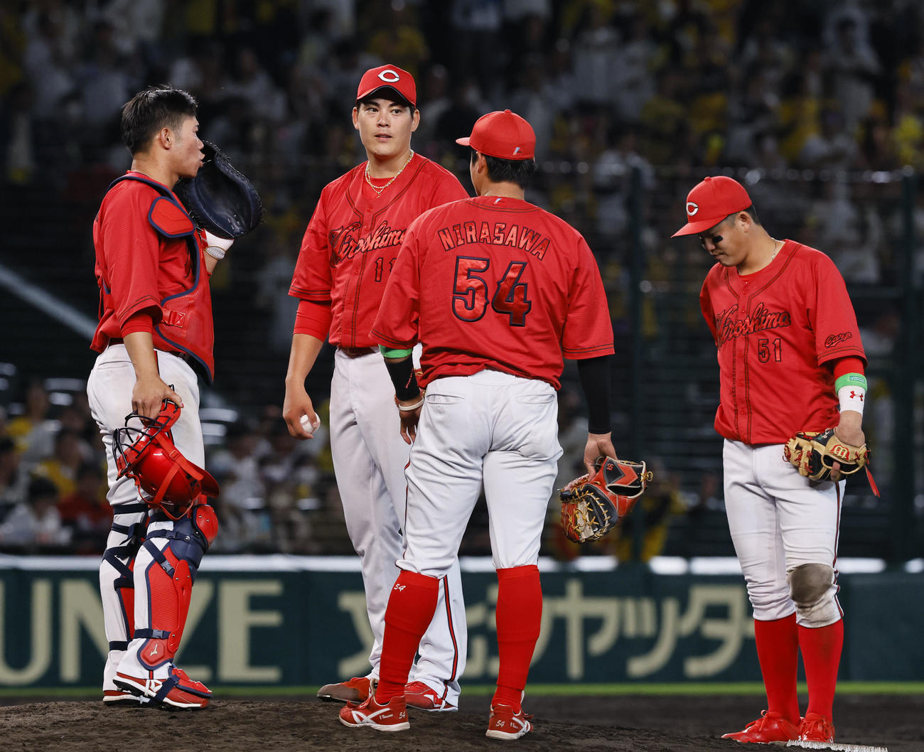 阪神対広島　5回裏阪神1死一、三塁、村上に勝ち越しの二塁打を許し、マウンドで声をかけられる広島九里（左から2人目）（撮影・藤尾明華）