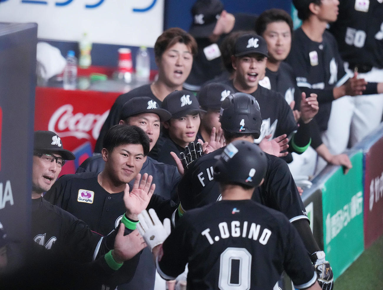 オリックス対ロッテ　1回表ロッテ1死二、三塁、ポランコの2点適時二塁打で生還した荻野貴（手前）を迎える吉井監督（左）らロッテベンチ（撮影・狩俣裕三）