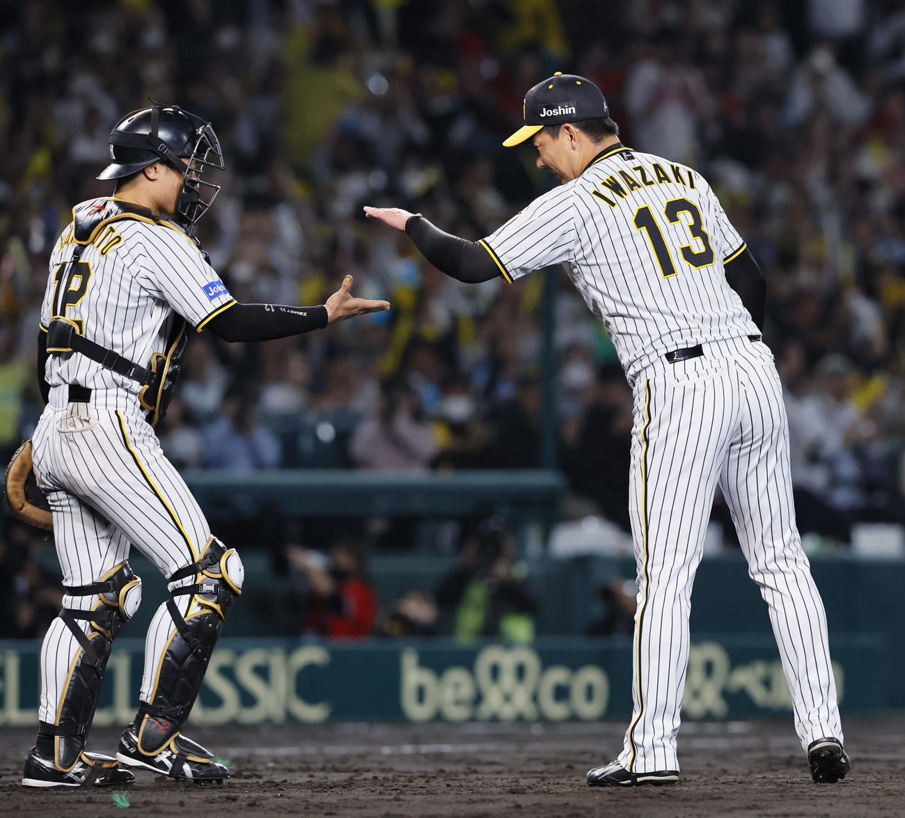 阪神対広島　9回を抑え、タッチを交わす阪神坂本（左）と岩崎（撮影・藤尾明華）