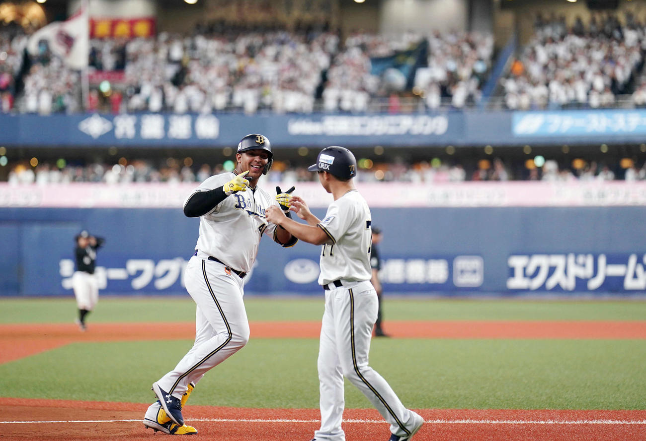 オリックス対ロッテ　7回裏オリックス2死一塁、2点本塁打を放ち、梵コーチ（右）にポーズを決めるセデーニョ（撮影・狩俣裕三）