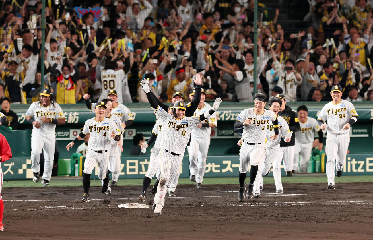 阪神対広島　9回裏阪神2死満塁、右前にサヨナラ打を放った木浪（手前）はバンザイ（撮影・加藤哉）