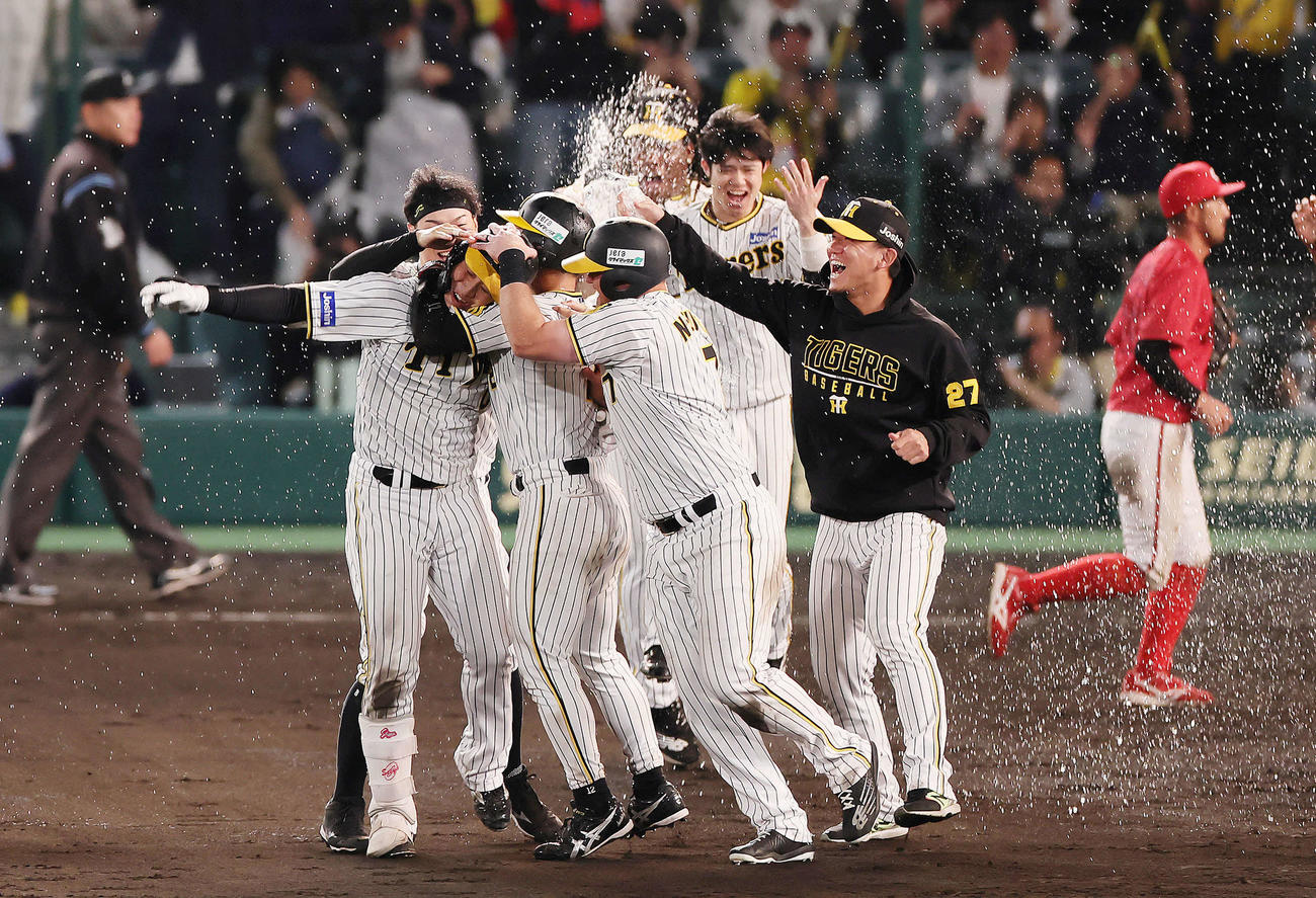 阪神対広島　9回裏阪神2死満塁、木浪（手前左端）はサヨナラ打を放ち手荒い祝福を受ける（撮影・足立雅史）
