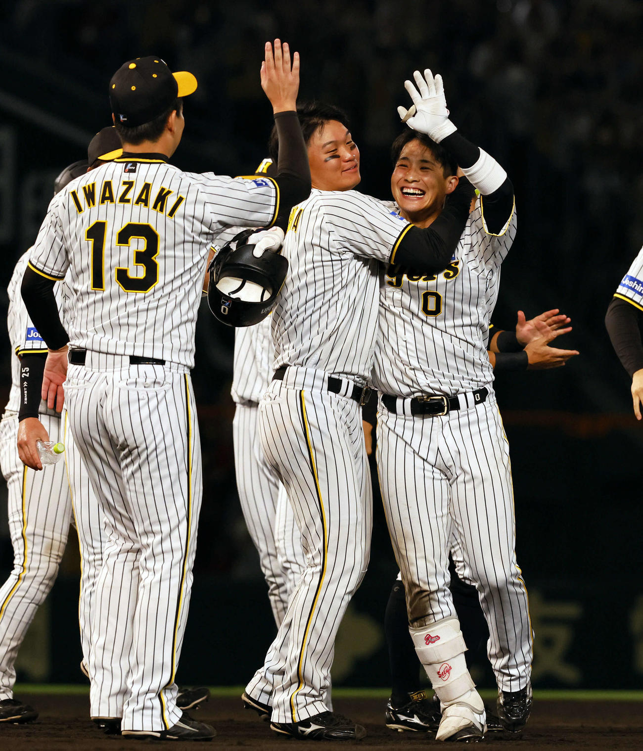 阪神対広島　9回裏阪神2死満塁、サヨナラ打を放ち岩崎（左）とタッチを交わす木浪（右）（撮影・藤尾明華）