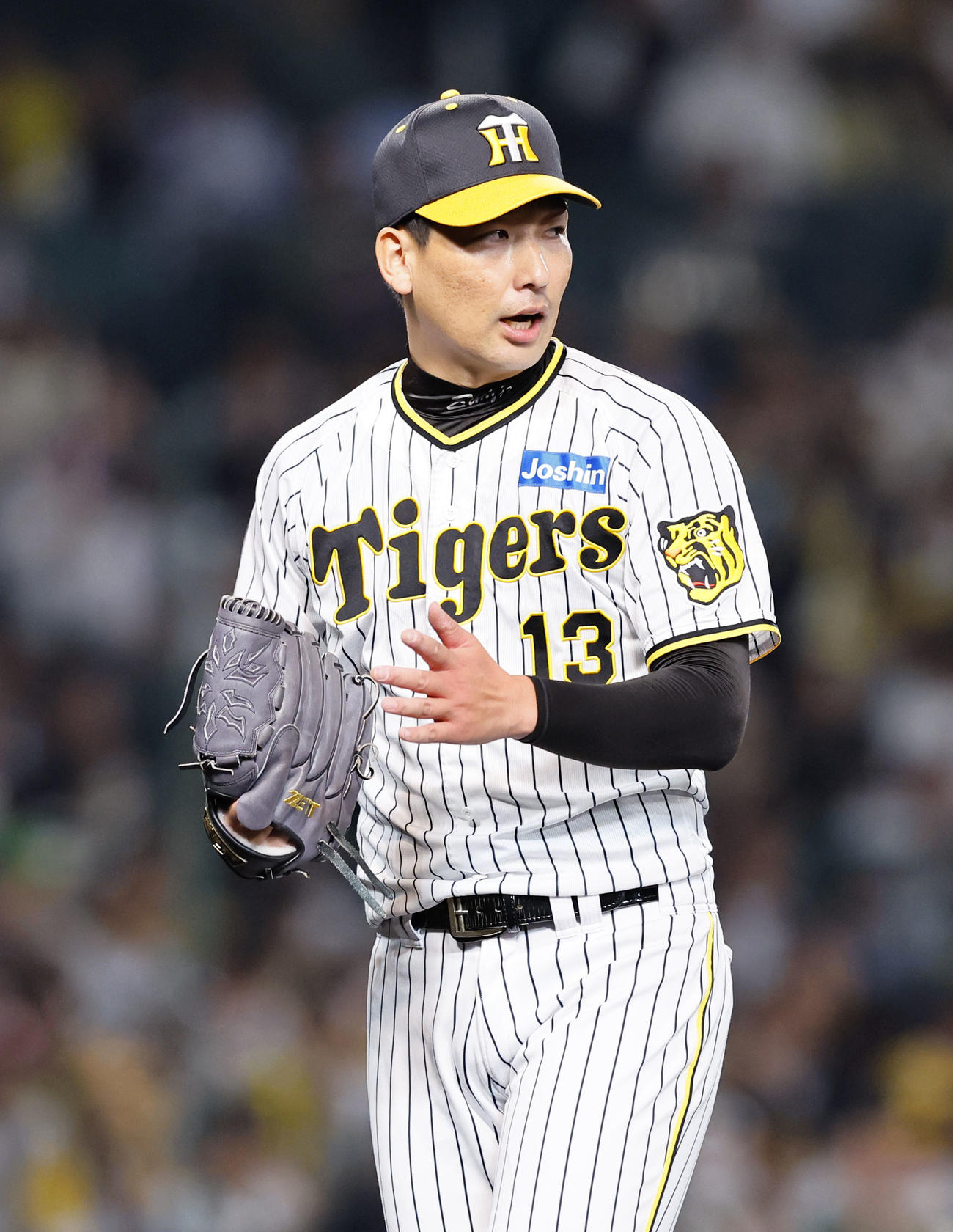 阪神対広島　9回を抑えグラブをたたく阪神岩崎（撮影・藤尾明華）