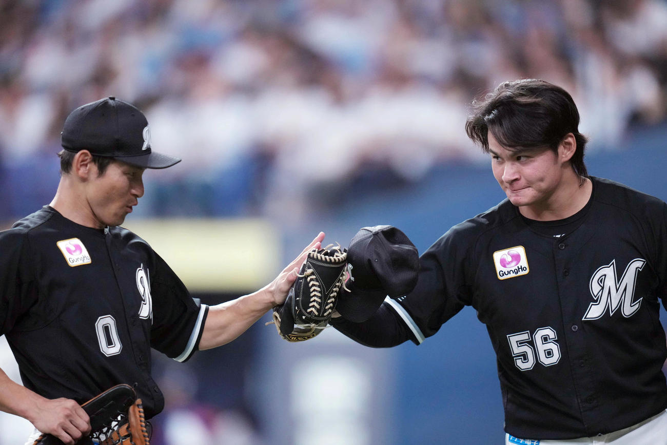 オリックス対ロッテ　3回裏を終え、この回に好守を見せた荻野貴（左）とタッチを交わす中森（撮影・狩俣裕三）