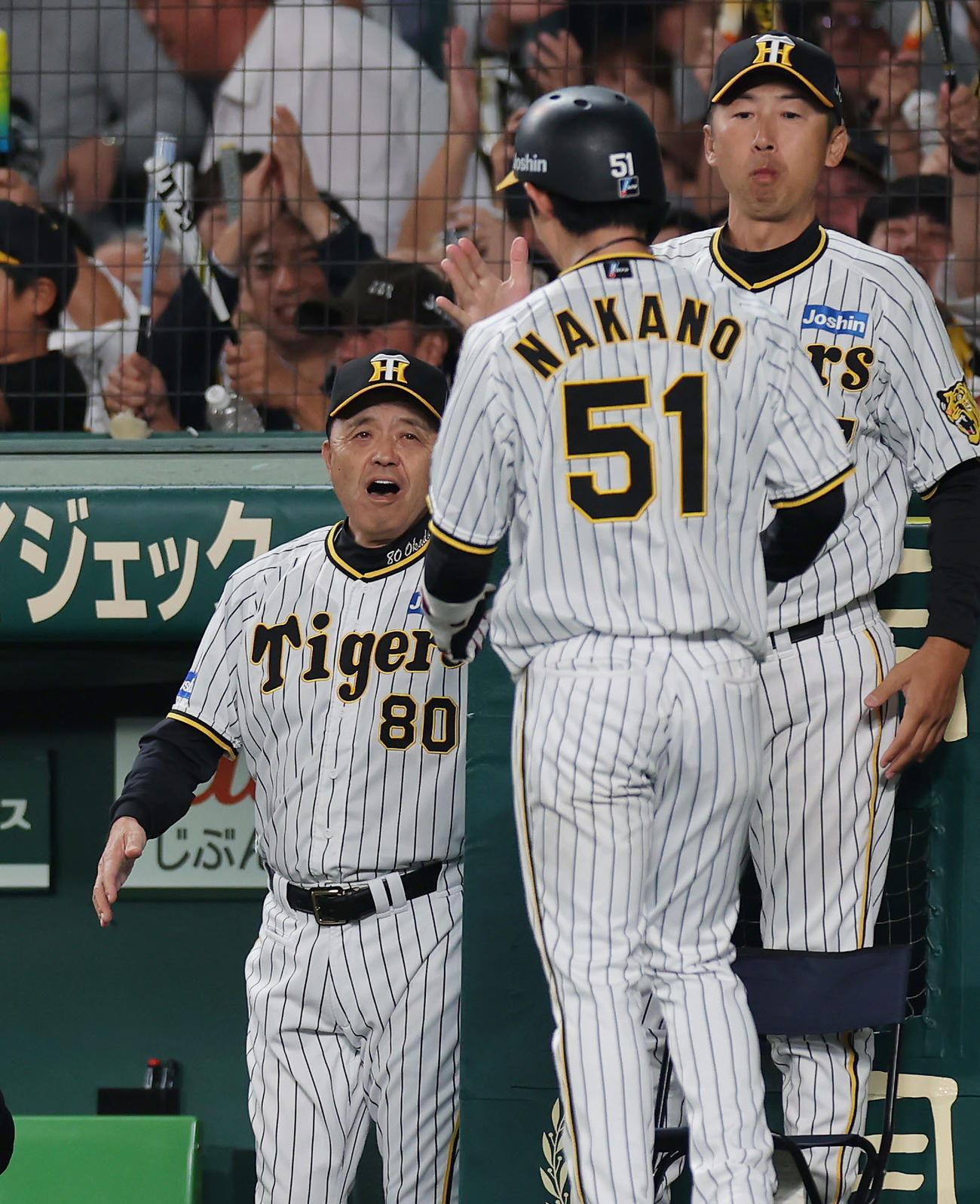 阪神対広島　4回裏阪神2死一、二塁、ノイジーの同点適時打で生還した中野（手前）を迎える岡田監督（左）（撮影・前田充）