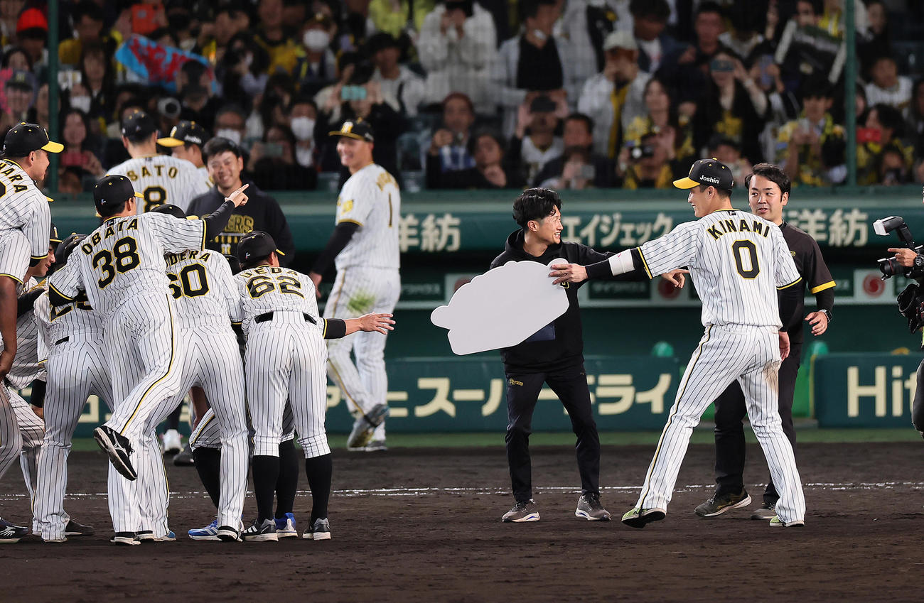 阪神対広島　記念撮影にMVPのボードを貸してあげる阪神木浪（右）（撮影・足立雅史）