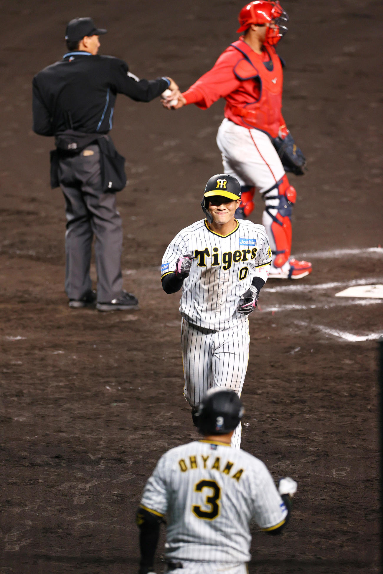 CSファイナル　阪神対広島　7回裏阪神1死満塁、木浪（中央）は森下の押し出し四球で生還し笑顔を見せる（撮影・上山淳一）