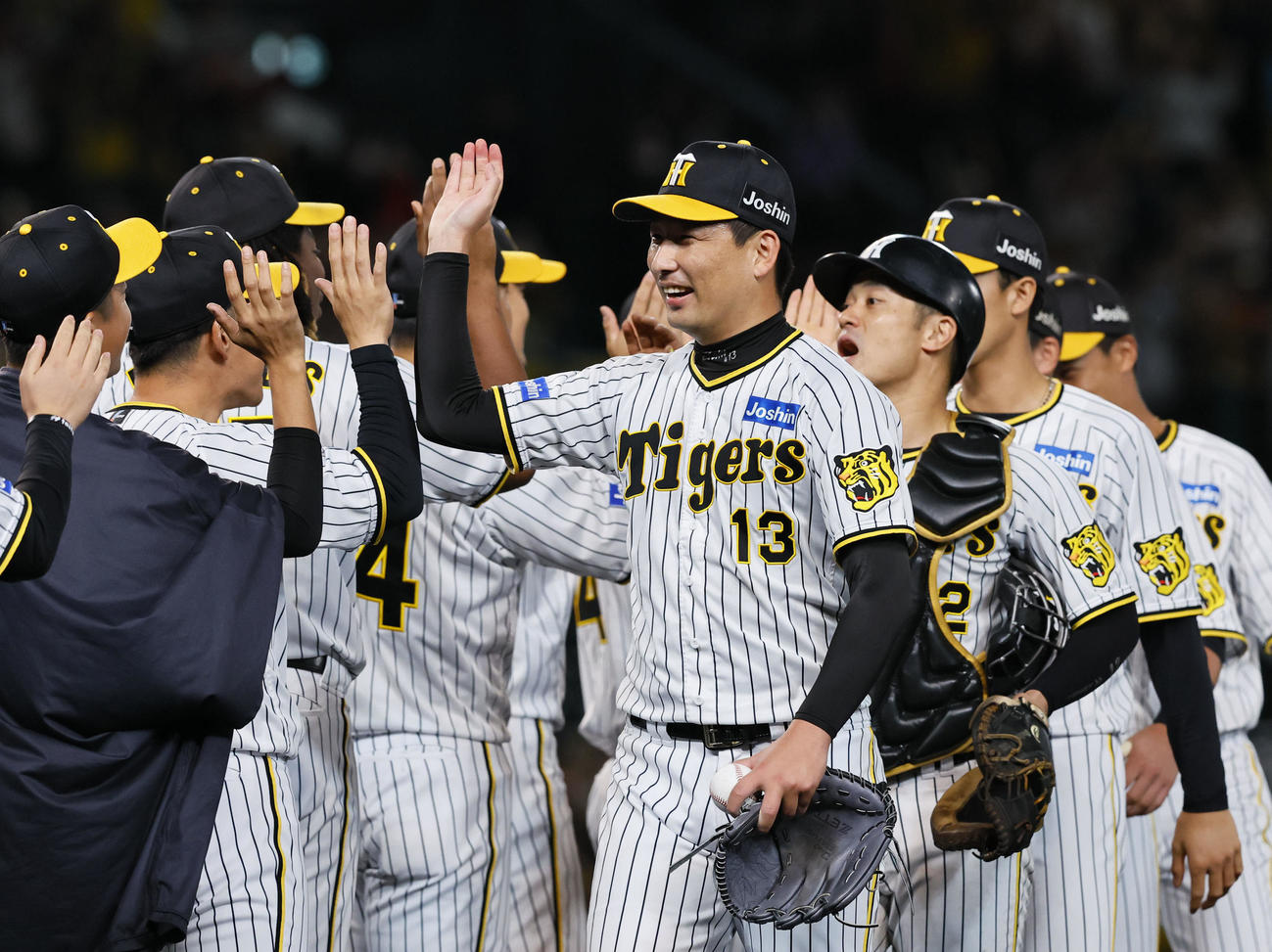 阪神対広島　日本シリーズ進出を決めタッチを交わす阪神岩崎（中央）（撮影・藤尾明華）