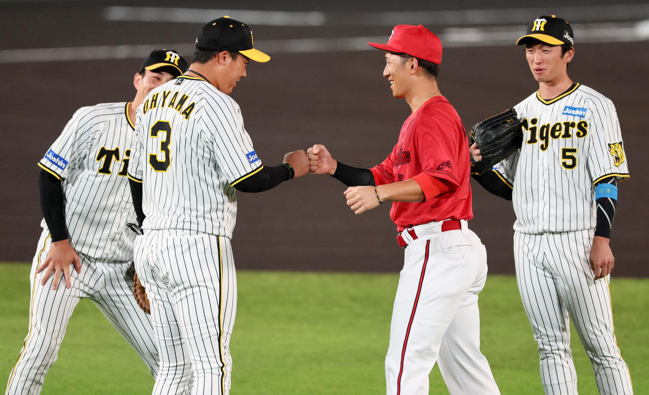 阪神対広島　試合前のウオーミングアップでグータッチする大山（左）と広島西川（撮影・加藤哉）