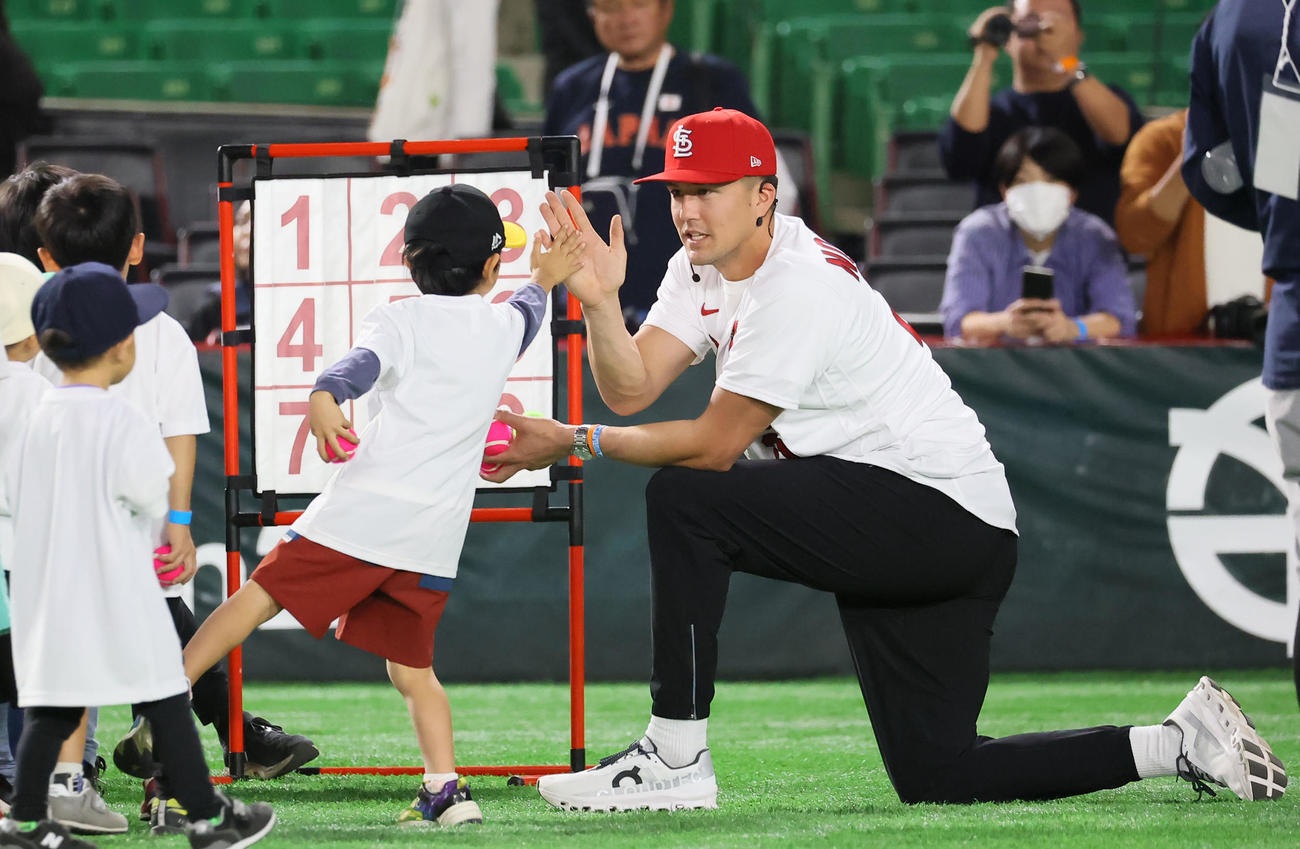 ボールを投げ終えた子どもとタッチを交わすヌートバー（撮影・冨田成美）