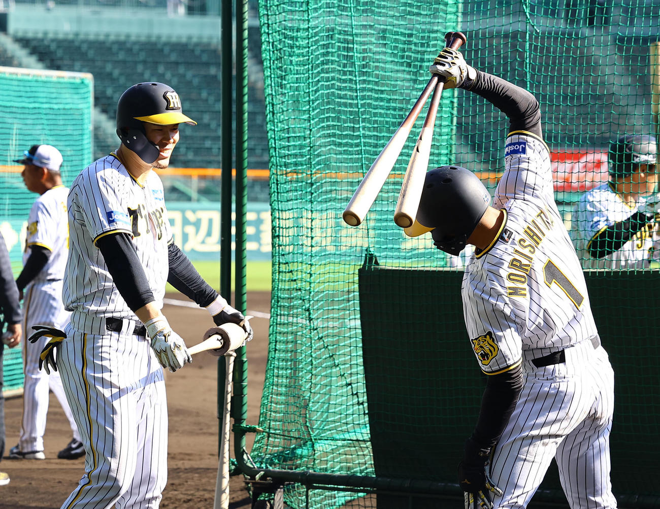 打撃練習の合間に話をする阪神佐藤輝（左）にと森下（撮影・藤尾明華）