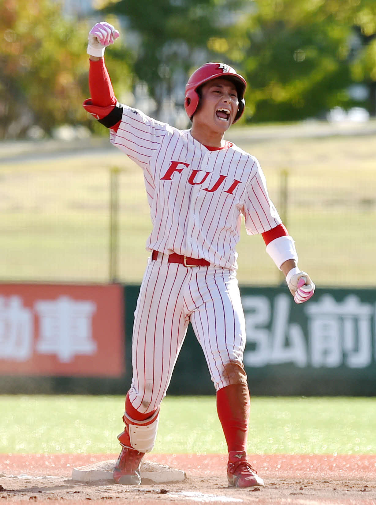 八戸学院大対富士大　3回裏富士大1死一、二塁、右中間に逆転2点適時三塁打を放ち、右腕を突き上げながら雄たけびを上げる後藤（撮影・相沢孔志）