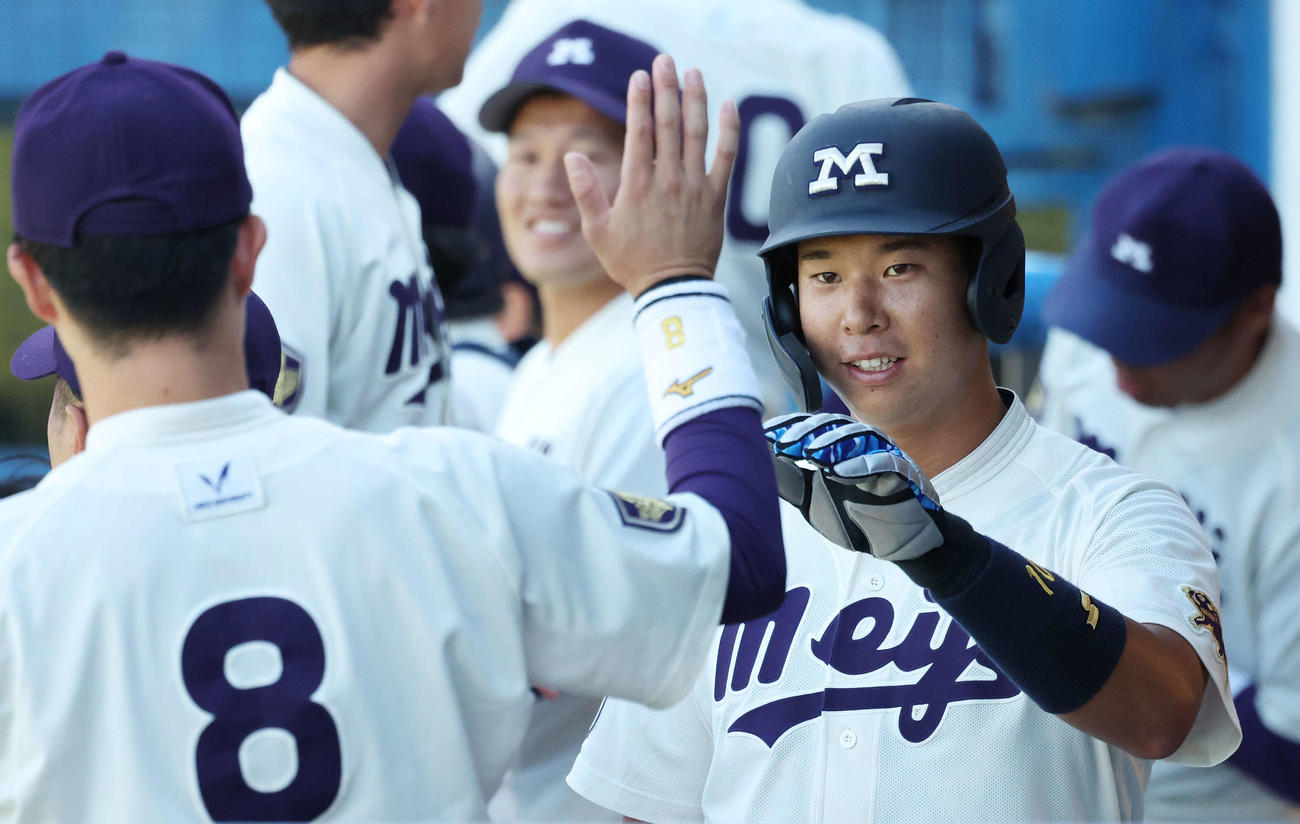 明大対法大　4回表明大1死一、三塁、榊原が同点右前適時打を放ち、生還した上田希は仲間とタッチを交わす（撮影・宮地輝）