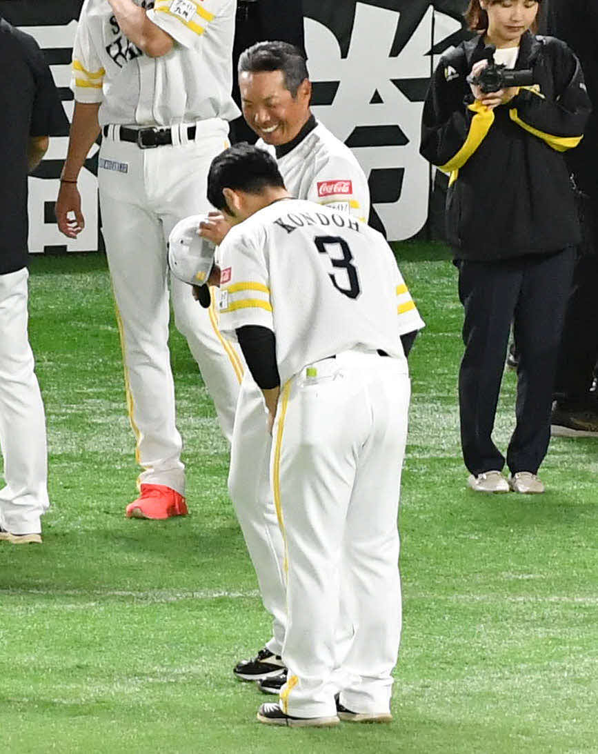 近藤（手前）にあいさつされて笑顔を見せる小久保新監督（撮影・岩下翔太）