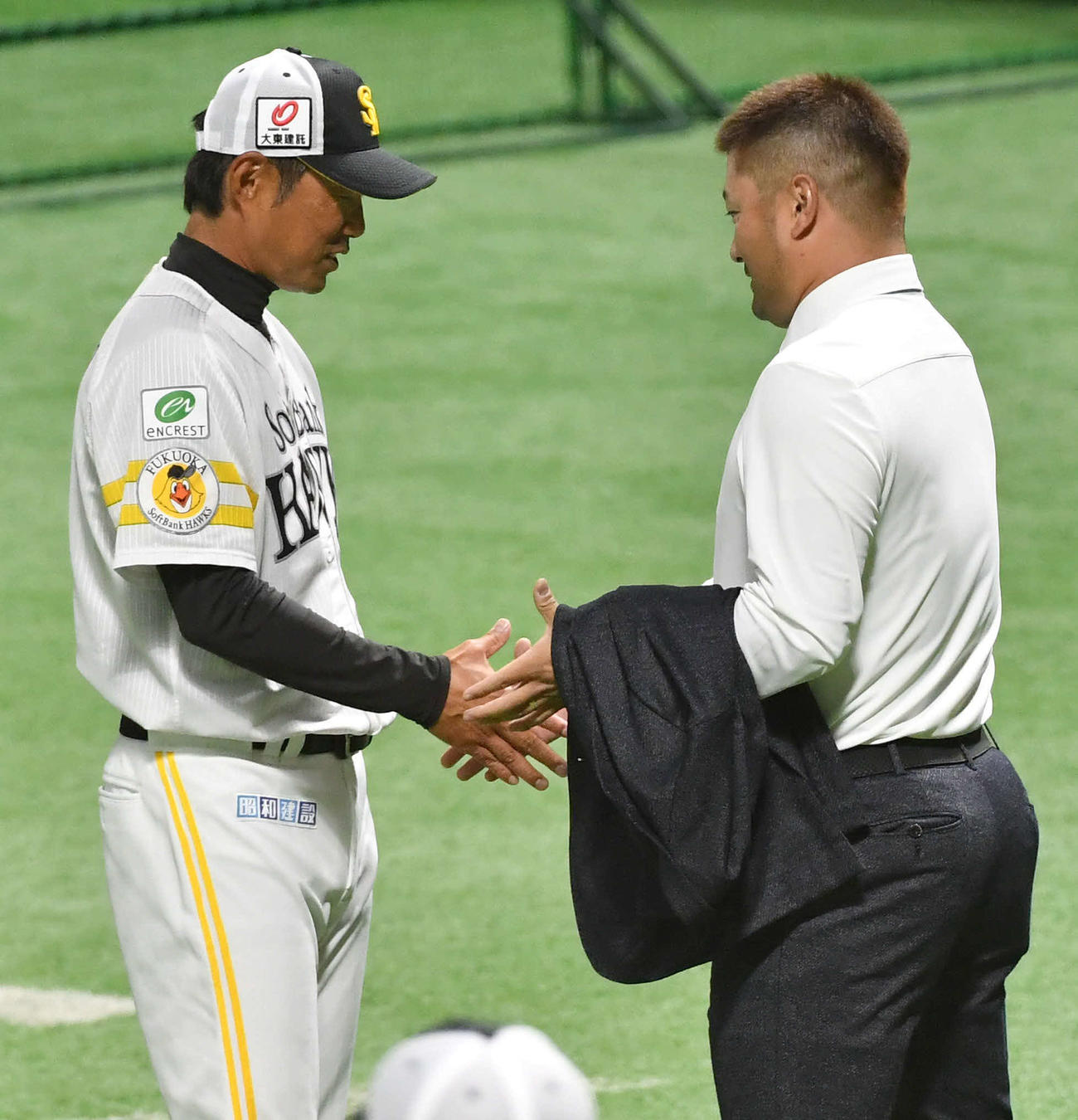 来季構想外となった森（右）からあいさつされ、握手を交わす小久保新監督（撮影・岩下翔太）