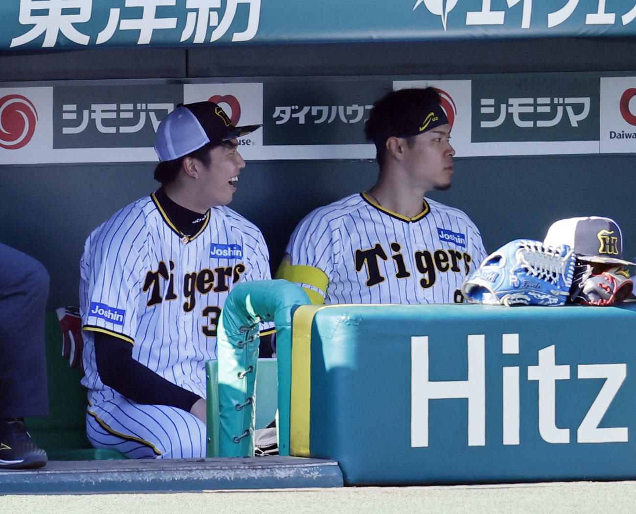 シート打撃の合間にベンチで笑顔を見せる阪神才木（左）（撮影・藤尾明華）