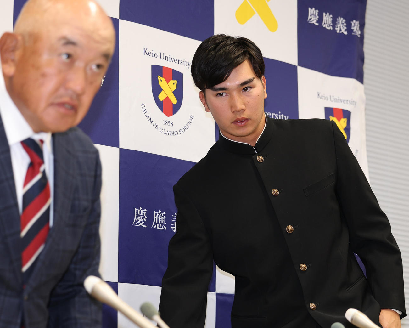 会見場に登場した慶大・広瀬。左は堀井監督（撮影・野上伸悟）