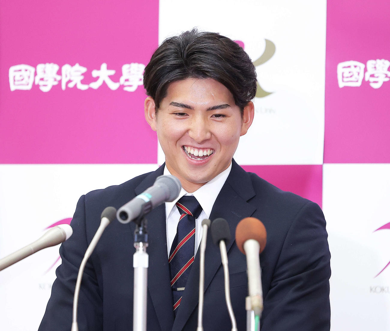 西武1位指名を受け、笑顔を見せる国学院大・武内（撮影・河田真司）