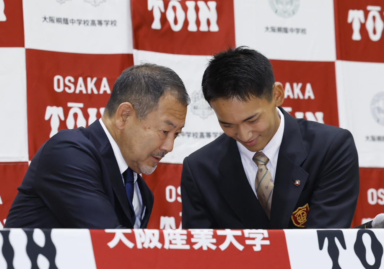 ソフトバンクから外れ1位での指名を受け、今田校長（左）と握手を交わす大阪桐蔭・前田（撮影・藤尾明華）