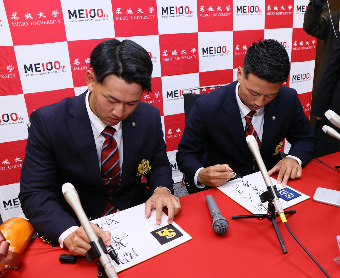 色紙に目標を書くソフトバンク2位の名城大の岩井（左）とDeNA2位の名城大の松本（撮影・上山淳一）