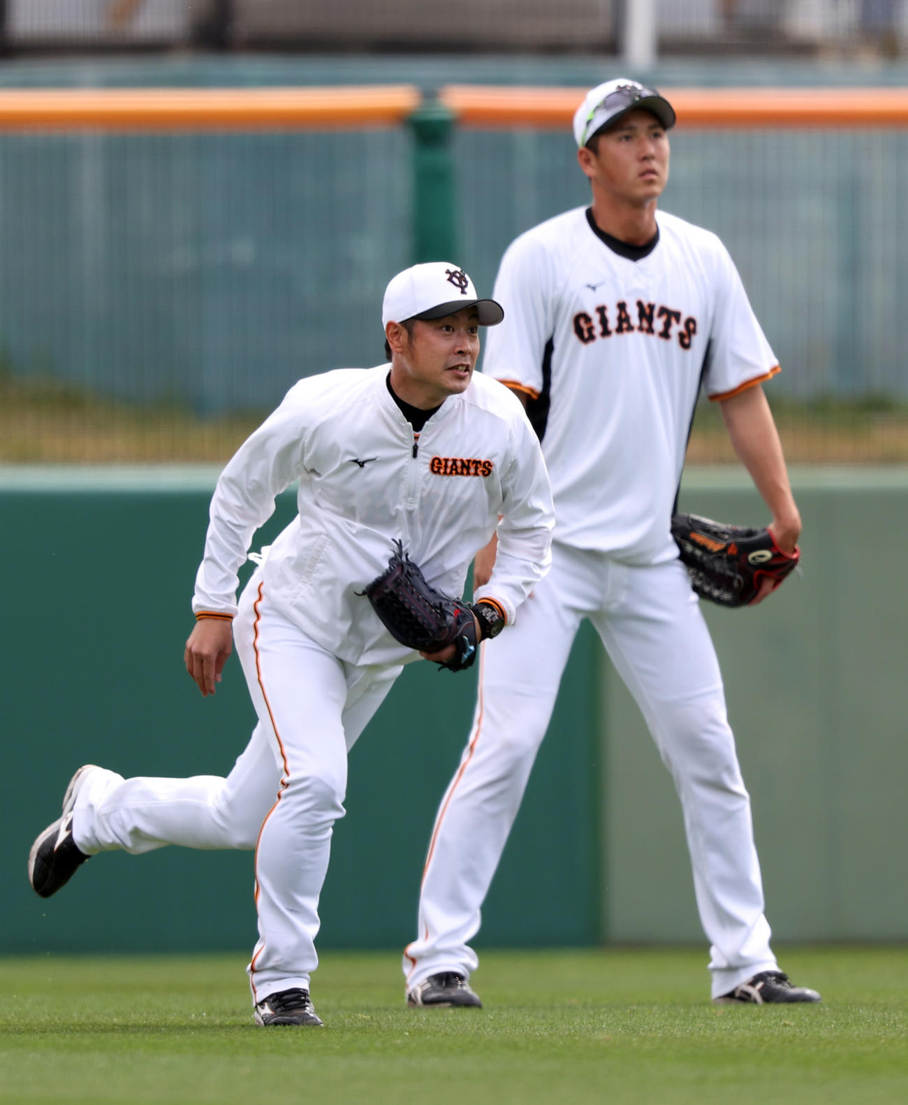 巨人秋広優人（後方）に外野守備の見本を見せる亀井善行外野守備兼走塁コーチ（2022年2月25日撮影）