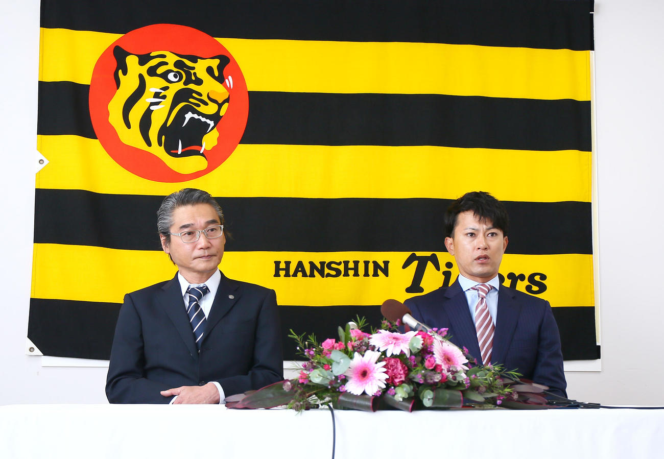 阪神コーチ就任会見で話す上本氏。左は嶌村球団本部長（撮影・上山淳一）
