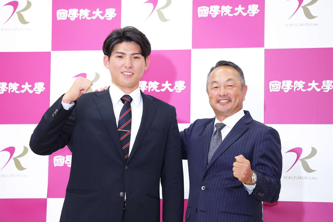 西武1位指名を受け、ガッツポーズで写真に納まる国学院大・武内（左）と鳥山監督（撮影・河田真司）