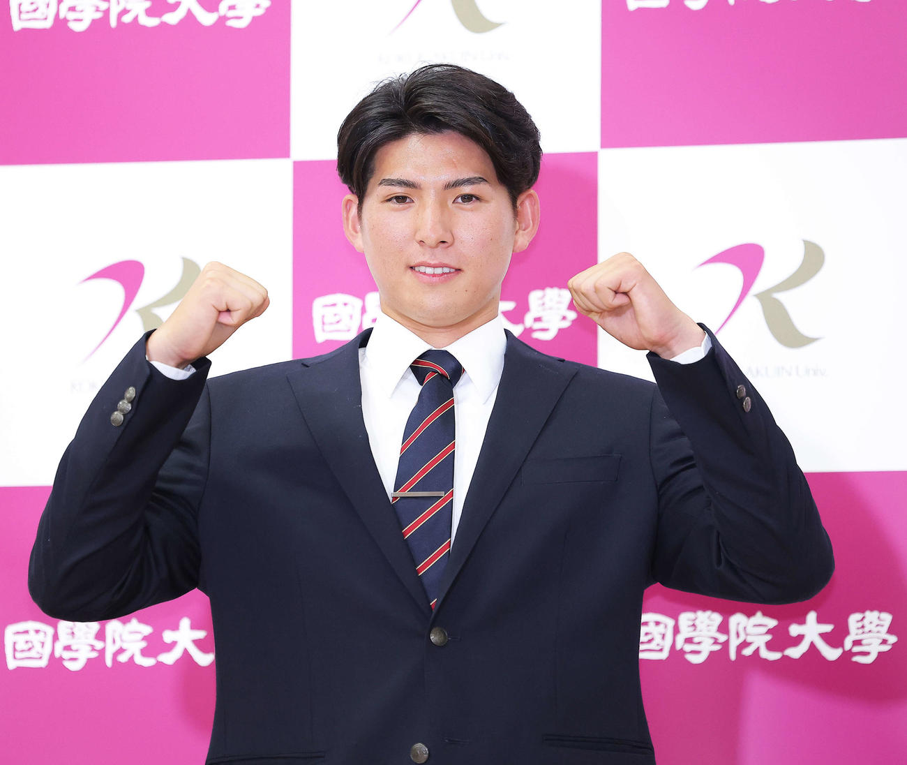 西武1位指名を受け、ガッツポーズで写真に納まる国学院大・武内（撮影・河田真司）