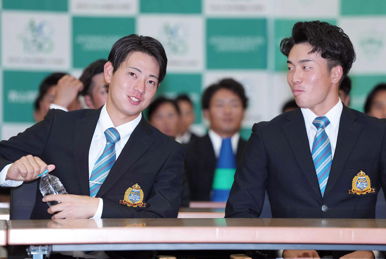 阪神から1位指名され、水を飲む青学大・下村（左）。右は常広（撮影・狩俣裕三）