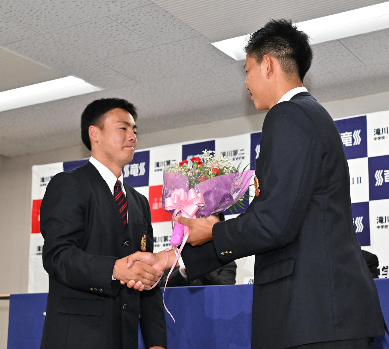 親友の田村武琉（左）から花束を贈呈される坂井陽翔（撮影・石井愛子）