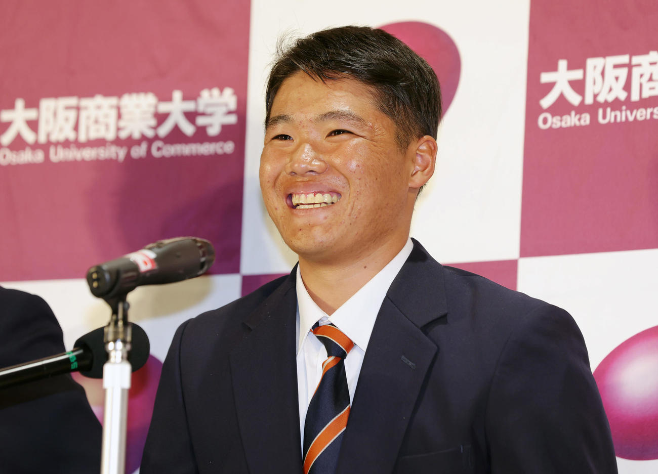 広島から2位指名を受け、会見で笑顔を見せる大商大・高（撮影・前田充）